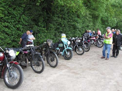 Organiser John Heywood, in day glow jacket, admires the line up of bikes at the finish